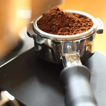 placing the ground coffee into the portafilter basket