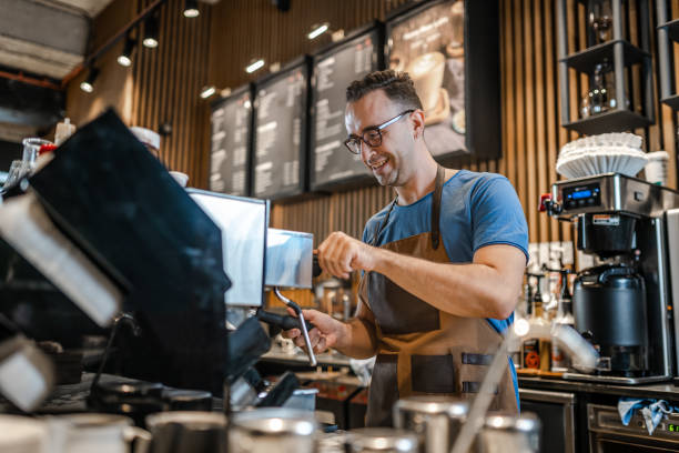 Smiling barista with stopwatch and espresso grinder next to pulled shot