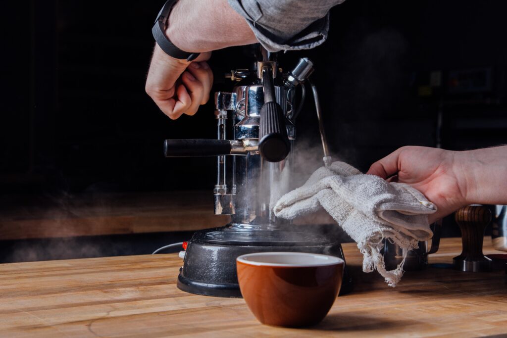 Barista pulling shot of washed Kenyan espresso on manual lever machine