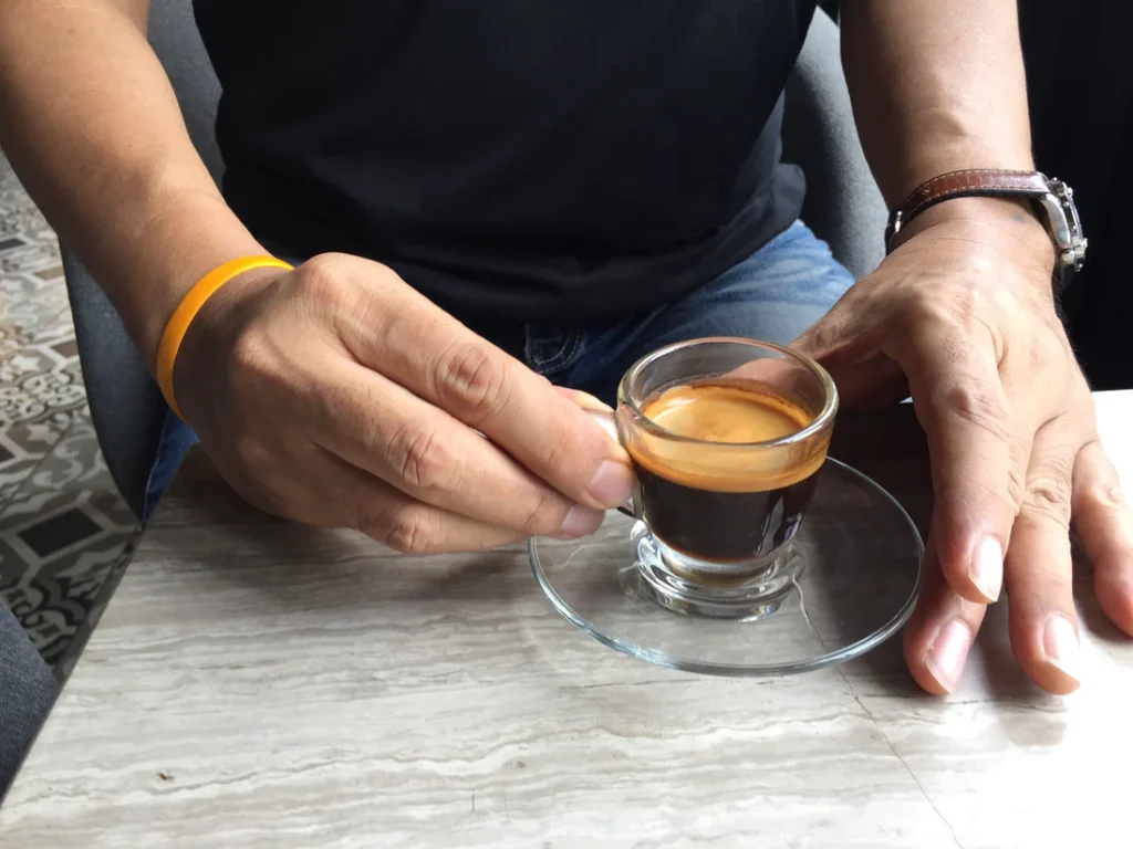 a man Having sip a shot of Colombian espresso